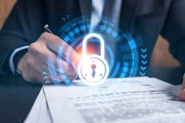 A closeup image of a person's hands holding a pen and signing a document. A lock icon floats in the foreground.